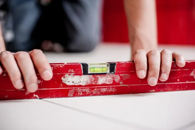 Installer checking a surface with a spirit level