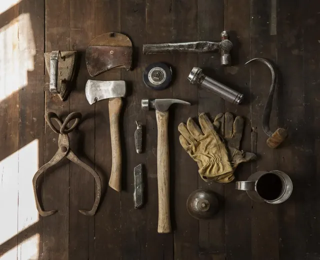Carpentry hand tools laid out on a wooden table